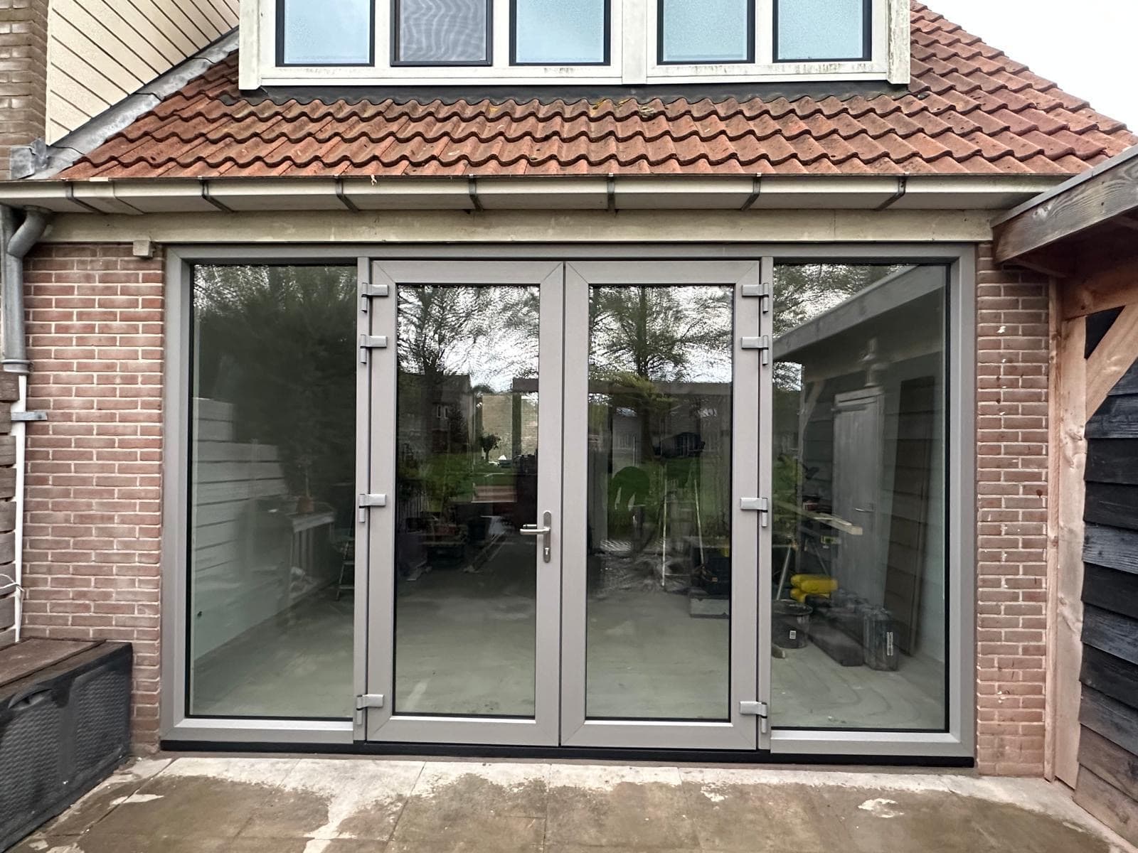 Openslaande kunststof tuindeuren in grijs, gezien vanuit de tuin